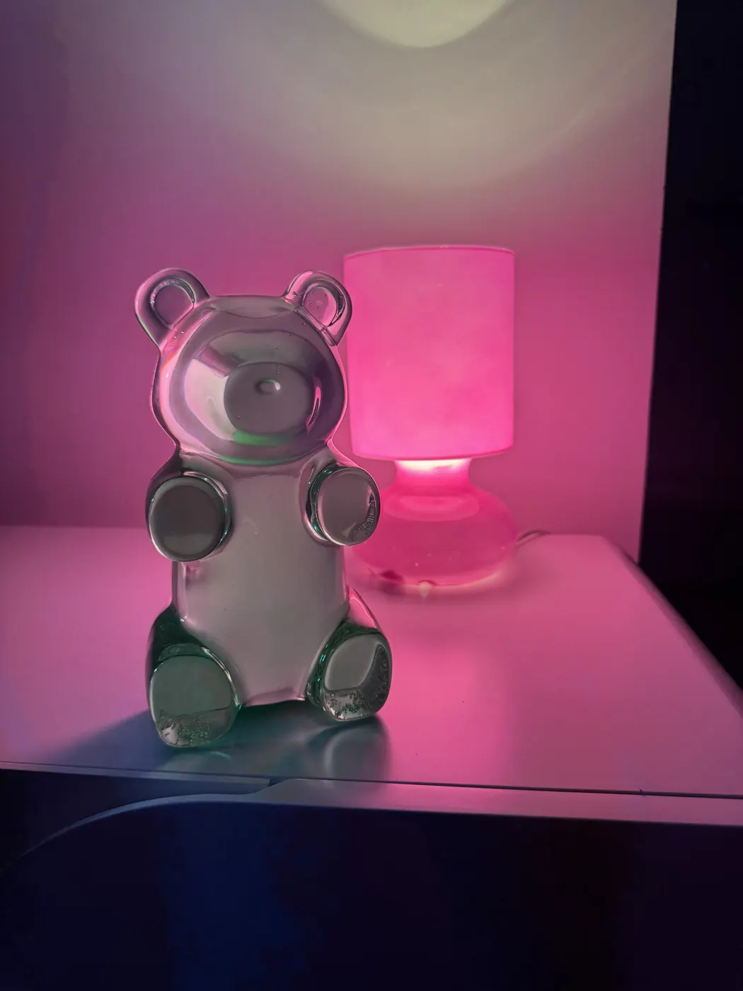 Ourson bonbon transparent à côté d’une lampe rose