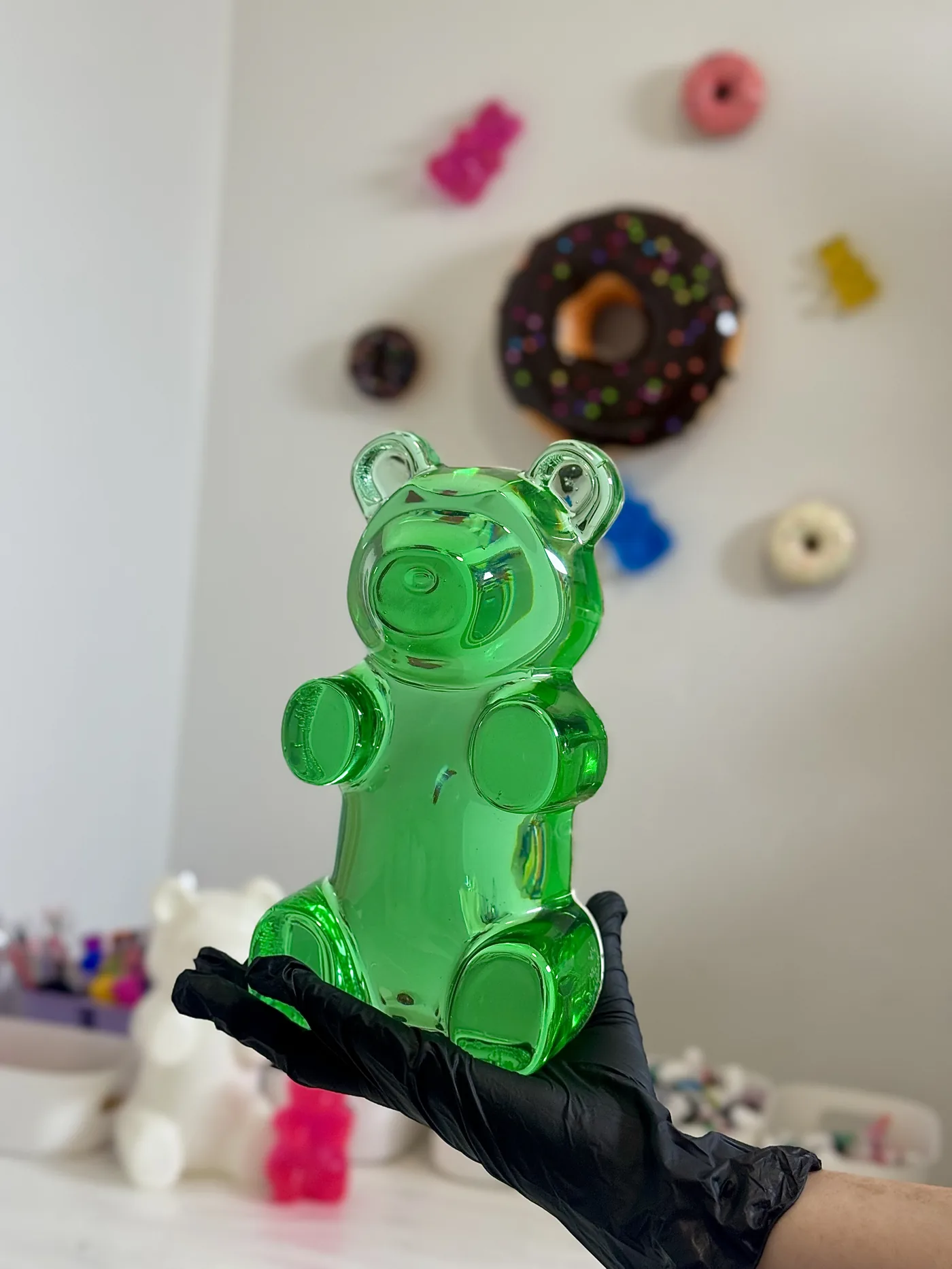 Orsetto gommoso gigante in resina verde nel laboratorio di Chromara Studio